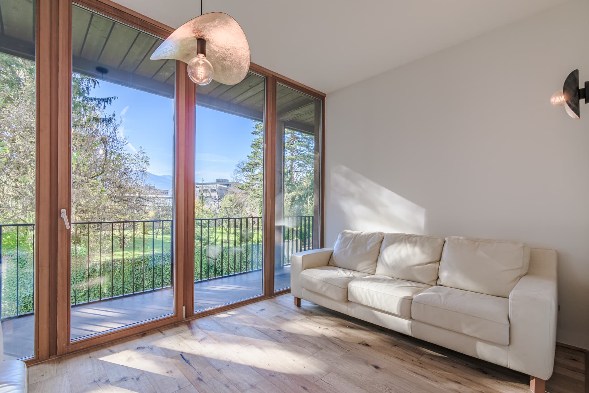 Wohnzimmer mit Balkonzugang und Parkblick